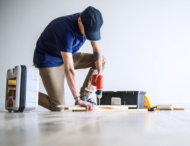 guy kneeling and screwing a board